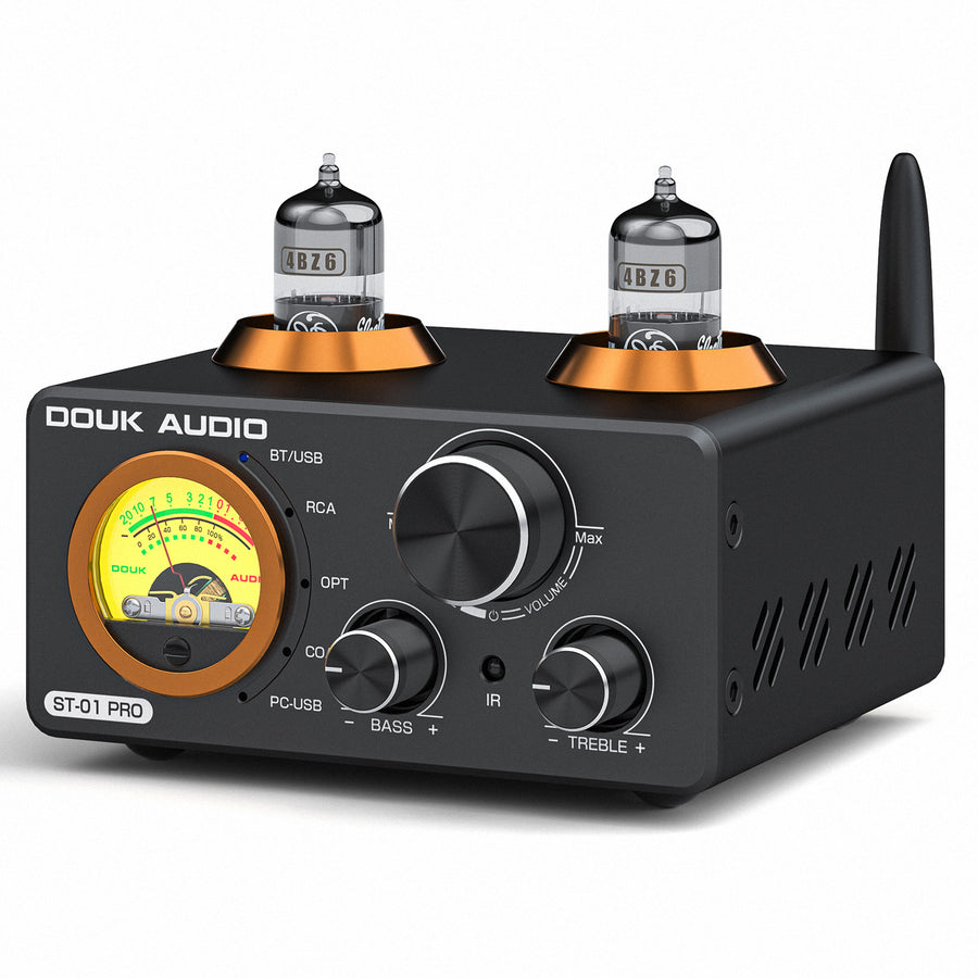 Black rectangular hybrid tube amplifier labeled DOUK AUDIO ST-01 PRO on a white background; two vacuum tubes in copper-ringed bases protrude from the top, an illuminated analog VU meter sits in an orange bezel on the left, and the front panel carries BASS and TREBLE knobs, a large central VOLUME knob, source labels for BT/USB, RCA, OPT, COAX and PC-USB, and a black antenna on the right side